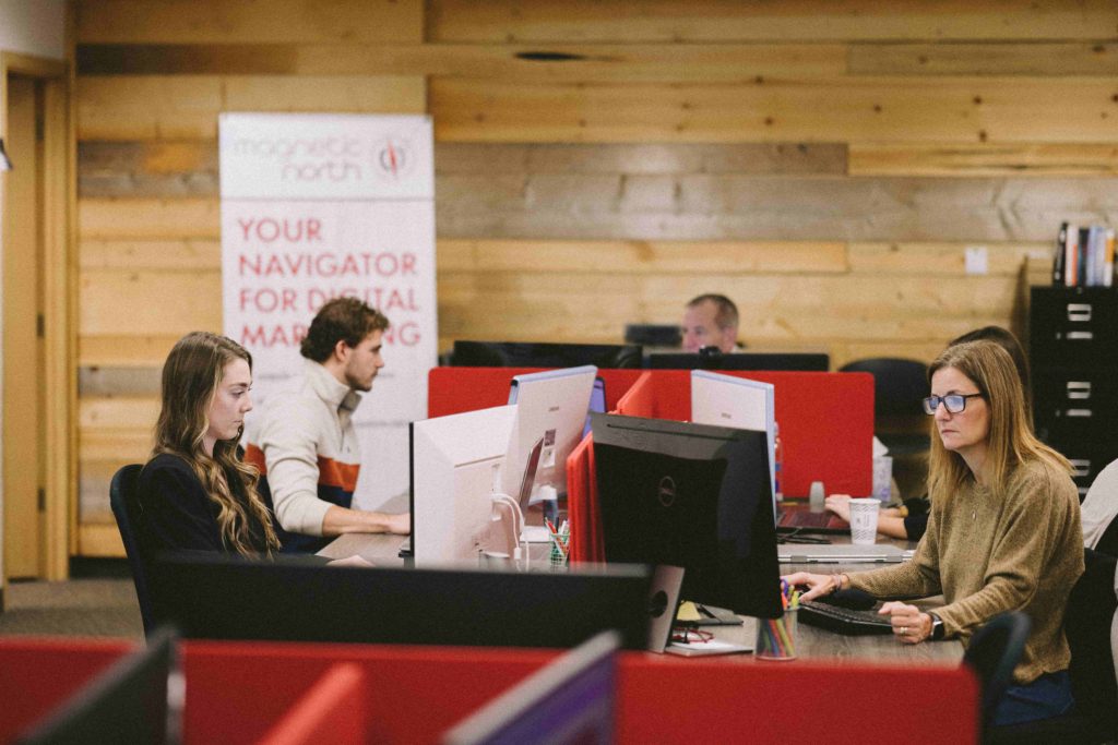 Coworkers at their desks working in the Magnetic North office.